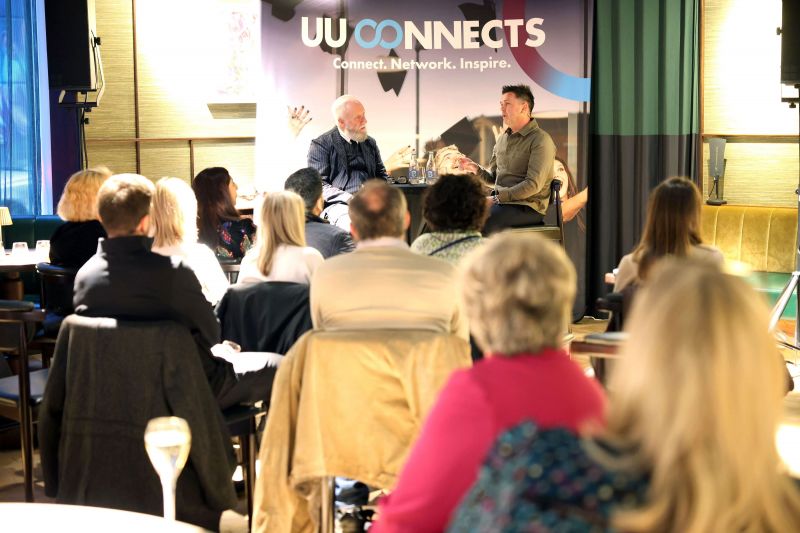 Another crowd POV picture showing Professor Paul Moore and Pete Snodden in discussion talking about Pete\'s life within the music industry with a UU Connects banner in the background