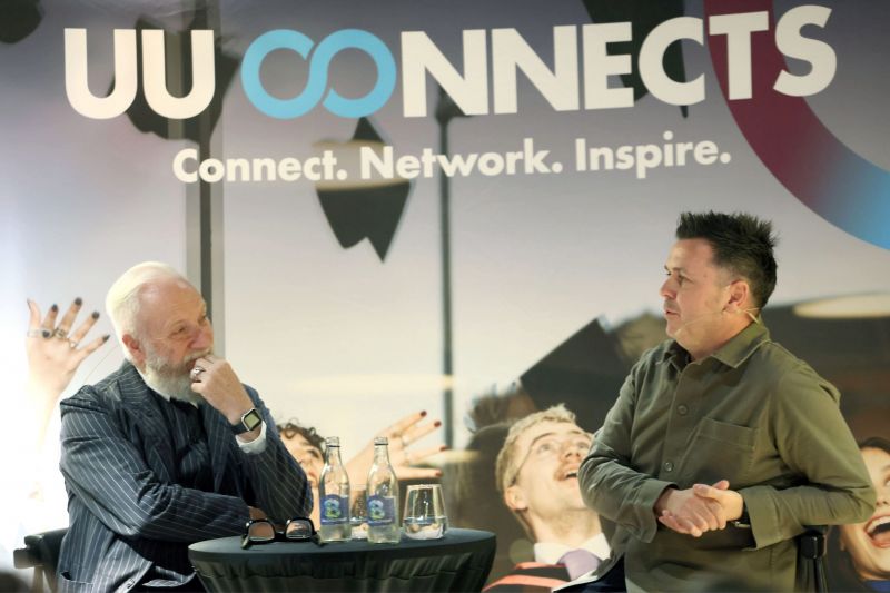 A close up picture of Pete Snodden and Professor Paul Moore deep in conversation with the UU Connects banner in the background